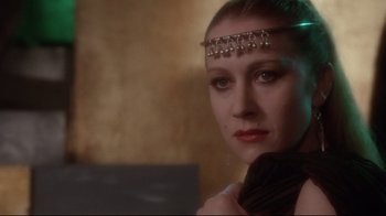 Movie still from “Excalibur” (1981), directed by John Boorman – A woman wearing a headpiece with bells on her head; Close Up shot, Over the shoulder angle