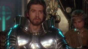 Movie still from “Excalibur” (1981), directed by John Boorman – A person wearing a suit of armor; Close Up shot, Over the shoulder angle