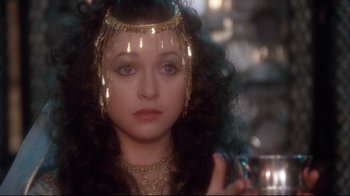 Movie still from “Excalibur” (1981), directed by John Boorman – A person with long hair wearing a crown; Close Up shot, Over the shoulder angle