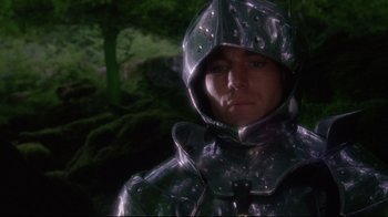 Movie still from “Excalibur” (1981), directed by John Boorman – A man in a metal suit in the woods; Close Up shot, Low angle