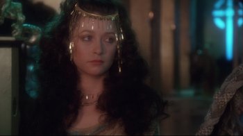 Movie still from “Excalibur” (1981), directed by John Boorman – A person with long hair wearing a crown; Close Up shot, Over the shoulder angle