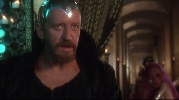 Movie still from “Excalibur” (1981), directed by John Boorman – A person with a beard wearing a helmet; Close Up shot, Over the shoulder angle