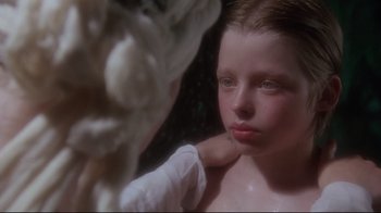Movie still from “Excalibur” (1981), directed by John Boorman – A young girl looking into a mirror while wearing a white glove; Close Up shot, Over the shoulder angle