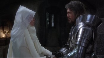 Movie still from “Excalibur” (1981), directed by John Boorman – A man and a woman dressed in medieval garb holding hands; Medium shot, Over the shoulder angle