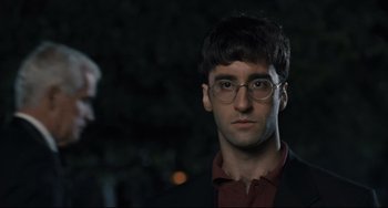 Movie still from “Exotica” (1994), directed by Atom Egoyan – A man wearing glasses and a suit and tie; Close Up shot, Over the shoulder angle