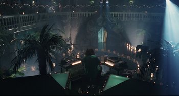 Movie still from “Exotica” (1994), directed by Atom Egoyan – A person sitting in a room with a bunch of candles; Extreme Wide shot, High angle