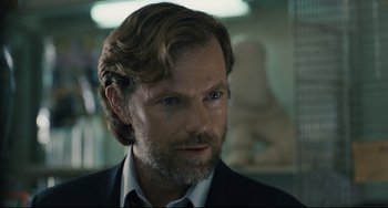 Movie still from “Exotica” (1994), directed by Atom Egoyan – A person wearing a suit and tie; Close Up shot, Over the shoulder angle