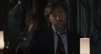 Movie still from “Exotica” (1994), directed by Atom Egoyan – A person wearing a suit and tie; Close Up shot, Over the shoulder angle