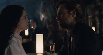 Movie still from “Exotica” (1994), directed by Atom Egoyan – A man and a woman sitting in front of each other at a table; Medium shot, Over the shoulder angle