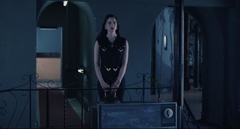 Movie still from “Exotica” (1994), directed by Atom Egoyan – A woman standing on top of a metal fence; Medium shot, Low angle