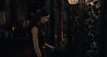 Movie still from “Exotica” (1994), directed by Atom Egoyan – A woman in a black dress looking into a mirror; Medium shot, Over the shoulder angle