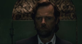 Movie still from “Exotica” (1994), directed by Atom Egoyan – A person wearing a suit and tie; Close Up shot, Low angle