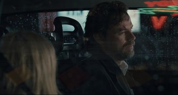 Movie still from “Exotica” (1994), directed by Atom Egoyan – A man sitting in the back seat of a car; Close Up shot, Over the shoulder angle