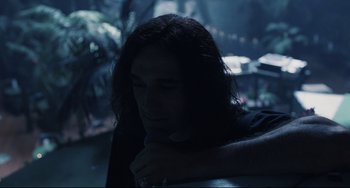 Movie still from “Exotica” (1994), directed by Atom Egoyan – A man with long hair is sitting in the dark; Close Up shot, High angle