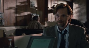 Movie still from “Exotica” (1994), directed by Atom Egoyan – A man sitting in front of a laptop computer; Close Up shot, Over the shoulder angle