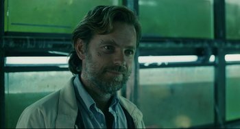 Movie still from “Exotica” (1994), directed by Atom Egoyan – A person with a beard; Close Up shot, Over the shoulder angle