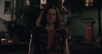 Movie still from “Exotica” (1994), directed by Atom Egoyan – A man with long curly hair wearing a red shirt; Medium shot, Over the shoulder angle