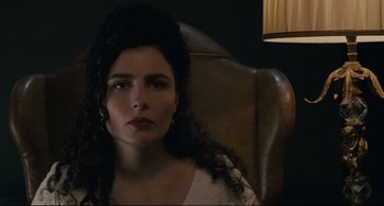 Movie still from “Exotica” (1994), directed by Atom Egoyan – A woman sitting in a leather chair looking at the camera; Close Up shot, Low angle