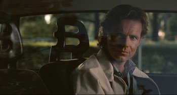 Movie still from “Exotica” (1994), directed by Atom Egoyan – A man sitting in the back seat of a car; Close Up shot, Over the shoulder angle