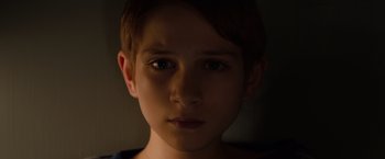 Movie still from “Extremely Loud & Incredibly Close” (2011), directed by Stephen Daldry – A young boy's face in the dark; Close Up shot, High angle