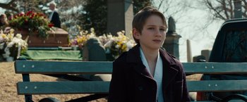 Movie still from “Extremely Loud & Incredibly Close” (2011), directed by Stephen Daldry – A young man sitting on a bench in a cemetery; Close Up shot, Over the shoulder angle