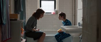 Movie still from “Extremely Loud & Incredibly Close” (2011), directed by Stephen Daldry – A woman and a boy sitting on a toilet in a bathroom; Medium shot, Over the shoulder angle