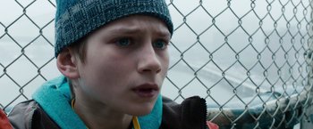 Movie still from “Extremely Loud & Incredibly Close” (2011), directed by Stephen Daldry – A young boy with blue eyes wearing a blue hat; Close Up shot, High angle