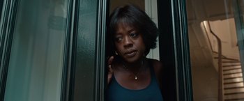 Movie still from “Extremely Loud & Incredibly Close” (2011), directed by Stephen Daldry – A woman standing next to a glass door looking at the camera; Close Up shot, Low angle