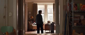 Movie still from “Extremely Loud & Incredibly Close” (2011), directed by Stephen Daldry – A man standing in a living room looking out a window; Wide shot, Over the shoulder angle
