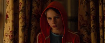 Movie still from “Extremely Loud & Incredibly Close” (2011), directed by Stephen Daldry – A young boy wearing a red hooded sweatshirt; Close Up shot, Over the shoulder angle