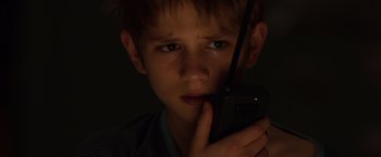 Movie still from “Extremely Loud & Incredibly Close” (2011), directed by Stephen Daldry – A young boy holding a cell phone up to his face; Close Up shot, High angle
