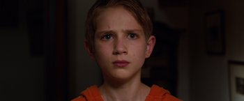 Movie still from “Extremely Loud & Incredibly Close” (2011), directed by Stephen Daldry – A young boy is looking into the camera; Close Up shot, Over the shoulder angle