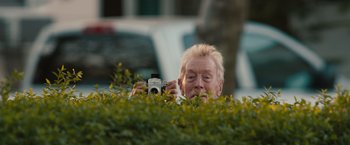 Movie still from “Extremely Loud & Incredibly Close” (2011), directed by Stephen Daldry – An older man taking a picture with a camera; Close Up shot, Low angle