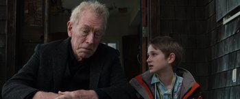 Movie still from “Extremely Loud & Incredibly Close” (2011), directed by Stephen Daldry – An older man and a young boy sitting next to each other; Close Up shot, Over the shoulder angle