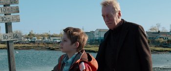 Movie still from “Extremely Loud & Incredibly Close” (2011), directed by Stephen Daldry – A man standing next to a boy near a body of water; Close Up shot, Over the shoulder angle