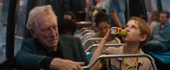 Movie still from “Extremely Loud & Incredibly Close” (2011), directed by Stephen Daldry – An older man sitting on a bus with a cigarette in his hand; Medium shot, Over the shoulder angle