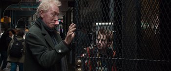 Movie still from “Extremely Loud & Incredibly Close” (2011), directed by Stephen Daldry – An older man looking at a young boy through a fence; Medium shot, Over the shoulder angle