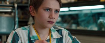 Movie still from “Extremely Loud & Incredibly Close” (2011), directed by Stephen Daldry – A young boy with blue eyes is looking into the distance; Close Up shot, Over the shoulder angle