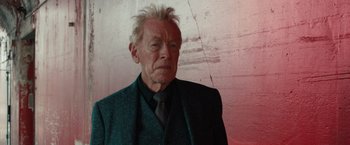 Movie still from “Extremely Loud & Incredibly Close” (2011), directed by Stephen Daldry – An older man in a green suit and a black tie; Close Up shot, Over the shoulder angle