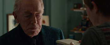 Movie still from “Extremely Loud & Incredibly Close” (2011), directed by Stephen Daldry – An older man holding a nintendo wii game controller; Close Up shot, Over the shoulder angle
