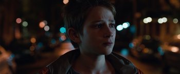 Movie still from “Extremely Loud & Incredibly Close” (2011), directed by Stephen Daldry – A young man with short brown hair looking to his left; Close Up shot, Over the shoulder angle