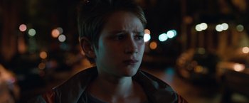 Movie still from “Extremely Loud & Incredibly Close” (2011), directed by Stephen Daldry – A young man with short blonde hair looking at the camera; Close Up shot, Over the shoulder angle