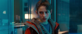 Movie still from “Extremely Loud & Incredibly Close” (2011), directed by Stephen Daldry – A young boy in a red jacket looking at the camera; Close Up shot, Over the shoulder angle