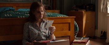 Movie still from “Extremely Loud & Incredibly Close” (2011), directed by Stephen Daldry – A woman sitting on a bed looking at a piece of paper; Medium shot, Over the shoulder angle