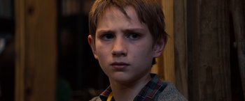 Movie still from “Extremely Loud & Incredibly Close” (2011), directed by Stephen Daldry – A young boy is looking into the camera; Close Up shot, Over the shoulder angle