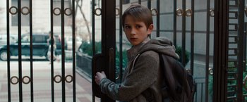Movie still from “Extremely Loud & Incredibly Close” (2011), directed by Stephen Daldry – A boy with a backpack standing in front of a gate; Close Up shot, Over the shoulder angle