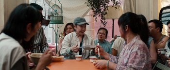 Movie still from “Extremely Loud & Incredibly Close” (2011), directed by Stephen Daldry – A group of people sitting at a table eating food; Medium shot, Over the shoulder angle