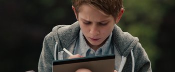 Movie still from “Extremely Loud & Incredibly Close” (2011), directed by Stephen Daldry – A young boy writing on a piece of paper; Close Up shot, Over the shoulder angle