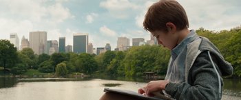 Movie still from “Extremely Loud & Incredibly Close” (2011), directed by Stephen Daldry – A young boy sitting in front of a body of water; Medium shot, High angle