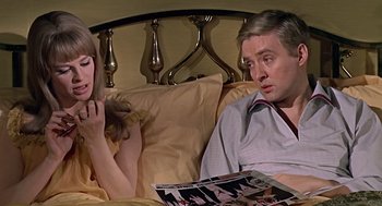 Movie still from “Fahrenheit 451” (1966), directed by François Truffaut – A man and a woman sitting on a bed looking at each other; Medium shot, High angle